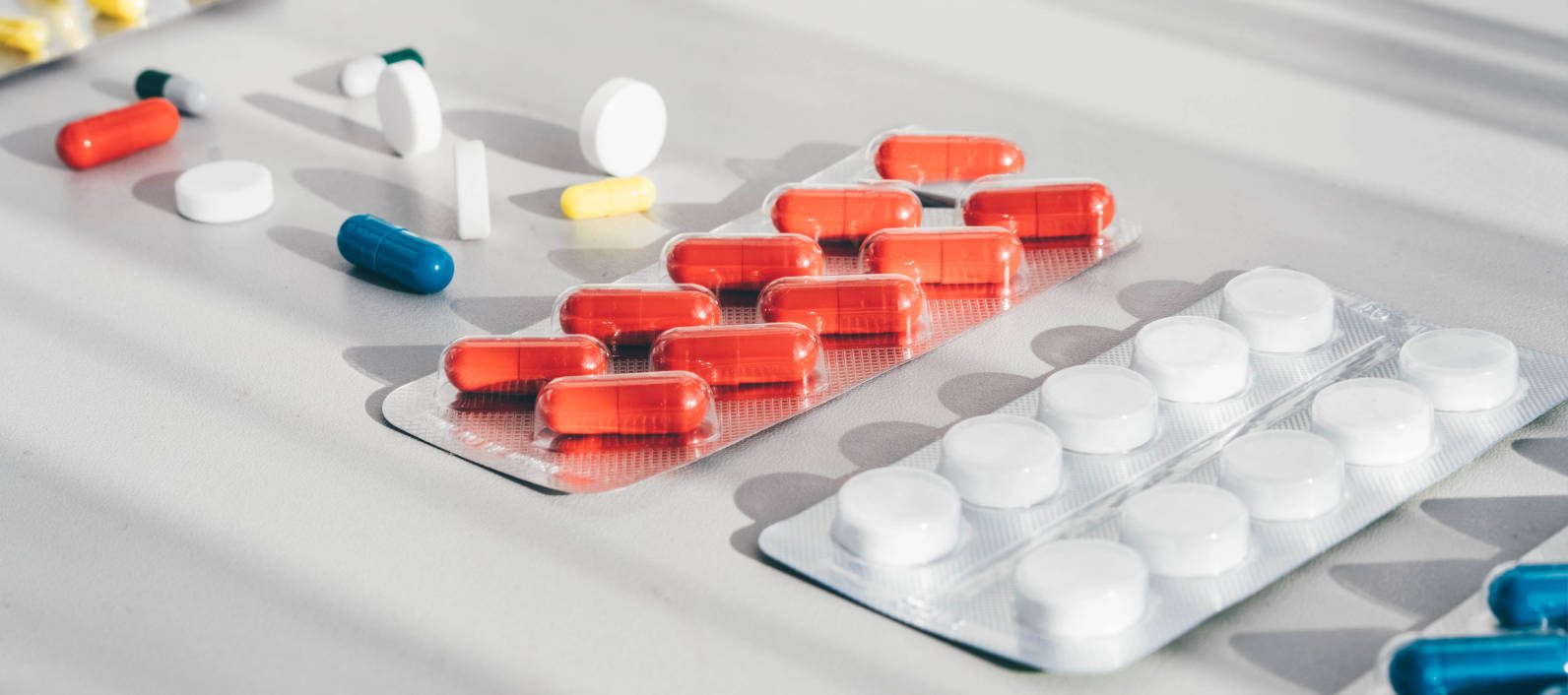 Medicine pills, tablets and capsules on white background. Top view.